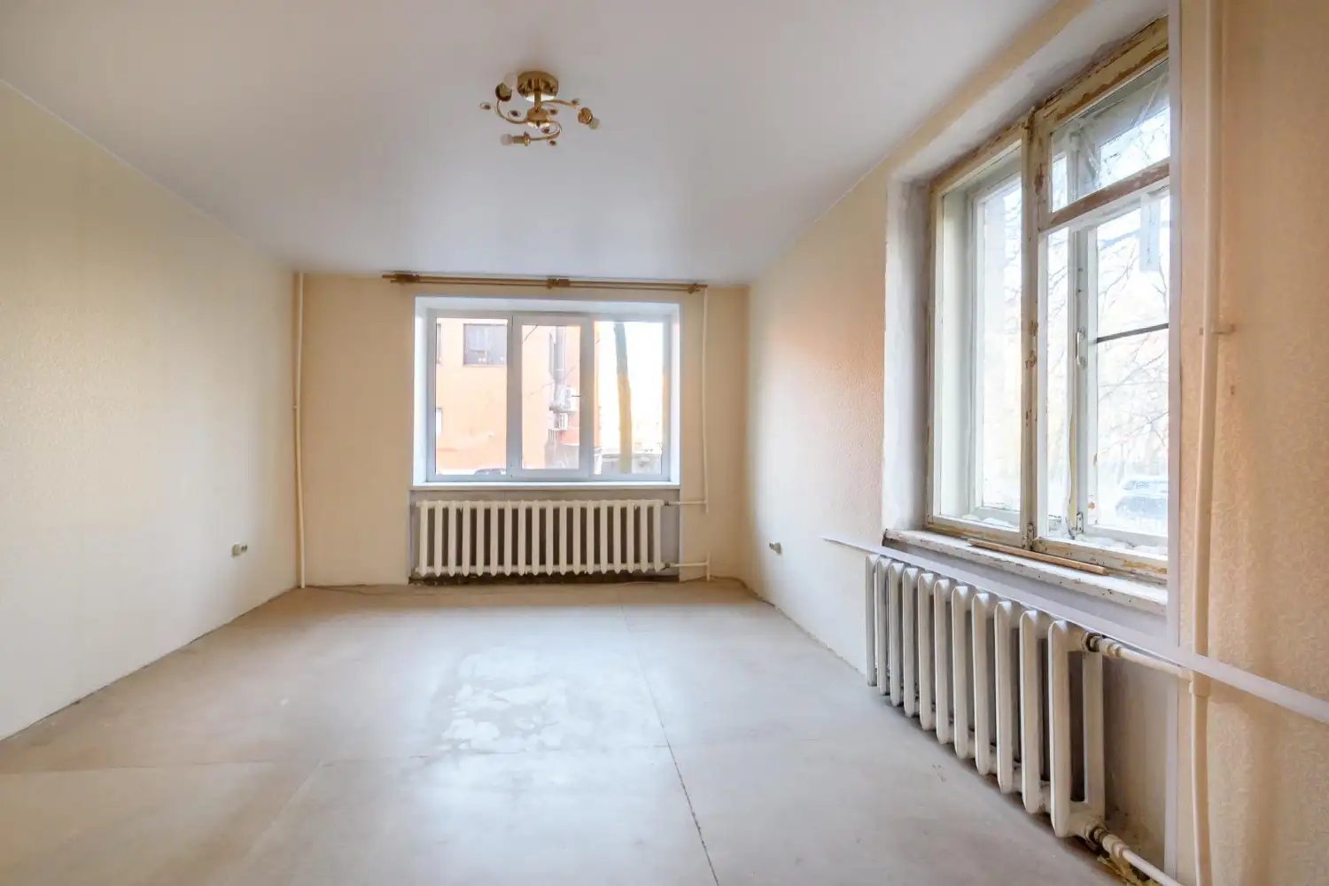 Leere Wohnung mit alten Heizkörpern in Wien als Beispiel für die Mieter Pflichten Auszug bei der Wohnungsübergabe